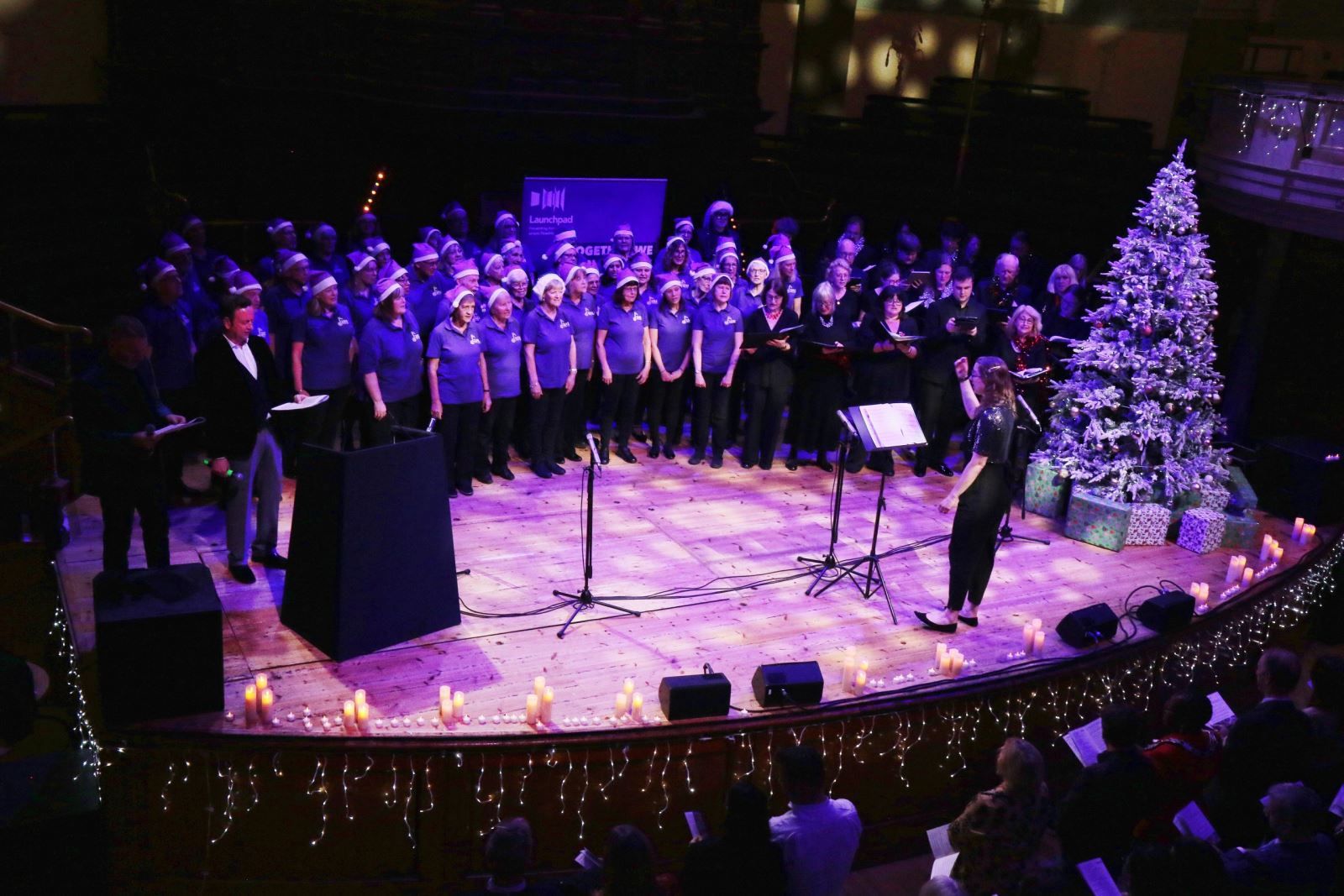Launchpad Carols by Candlelight - choir on stage with christmas tree